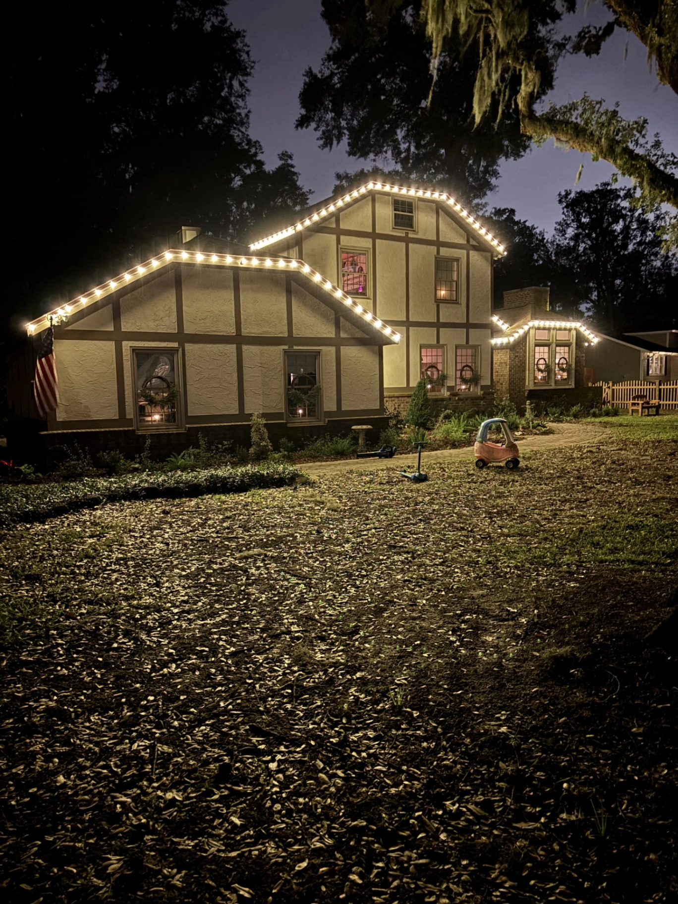 Elegant holiday lighting on a Tudor-style home